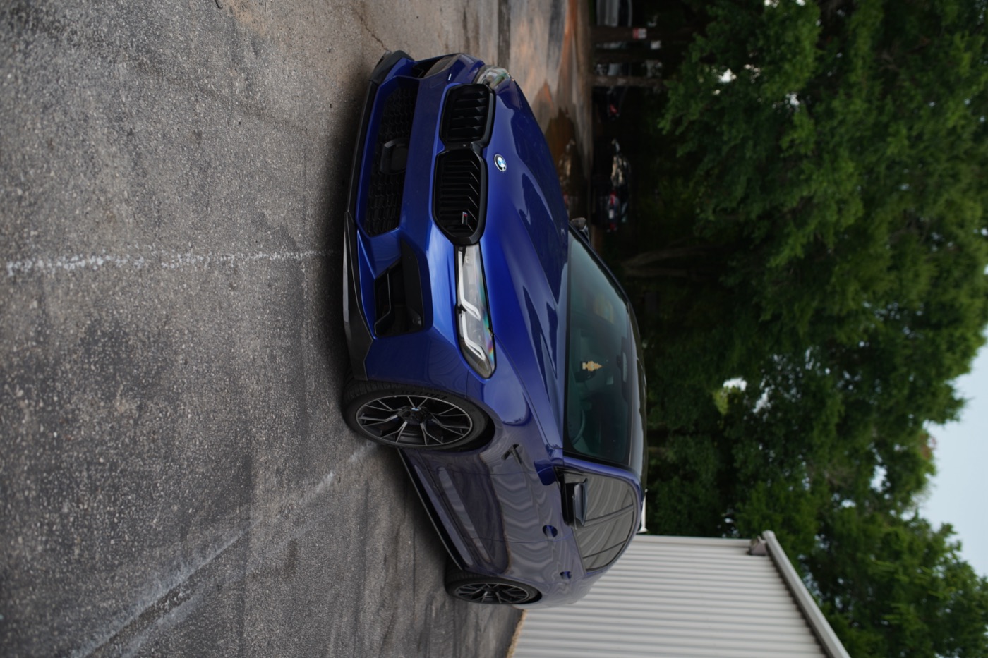 Blue BMW front view outside the shop
