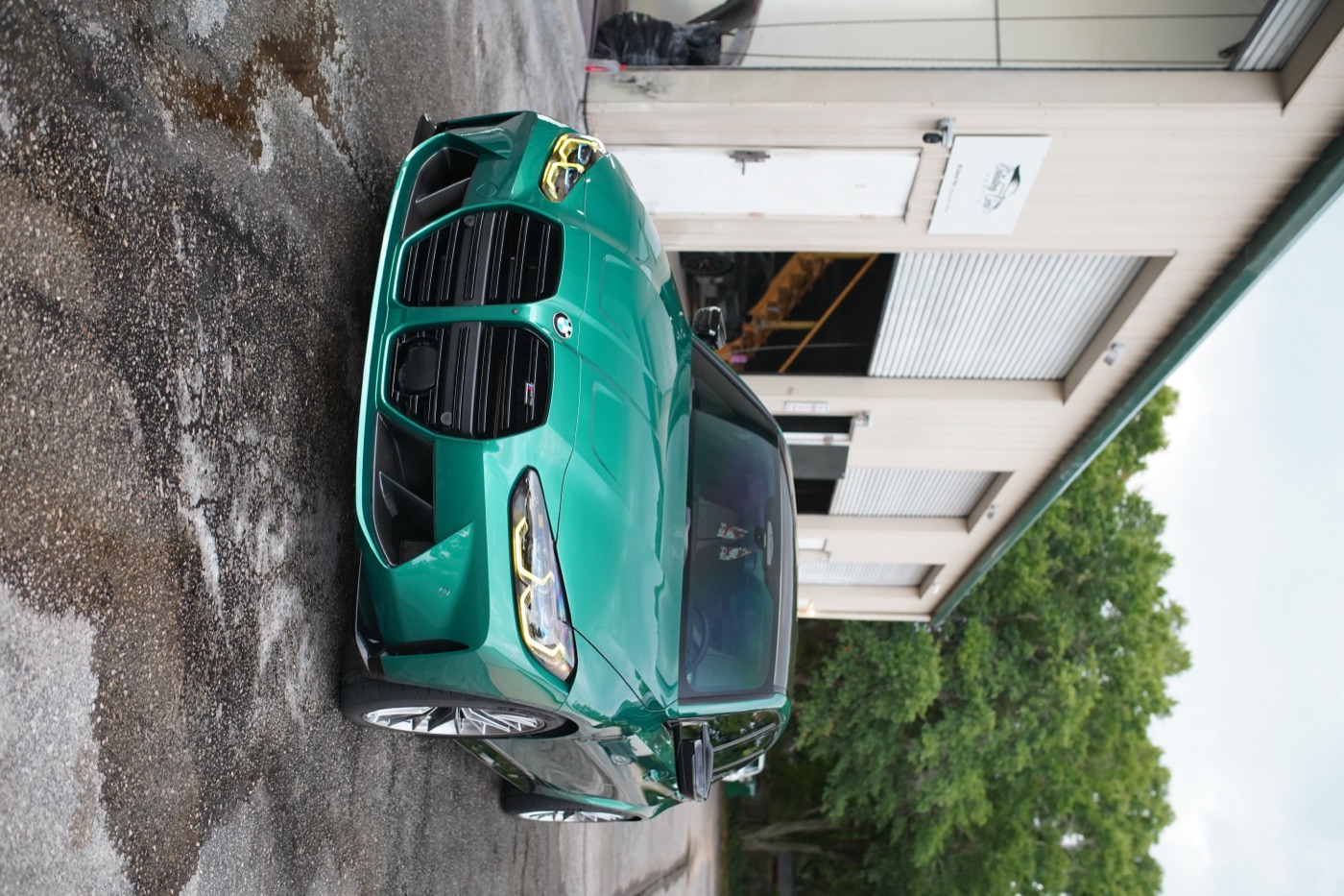 Green BMW M3 outside the shop
