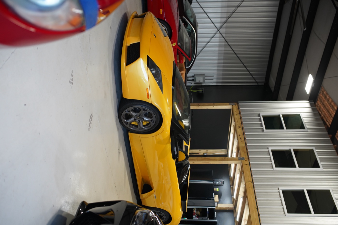 Yellow Lamborghini next to a red Ferrari in the shop