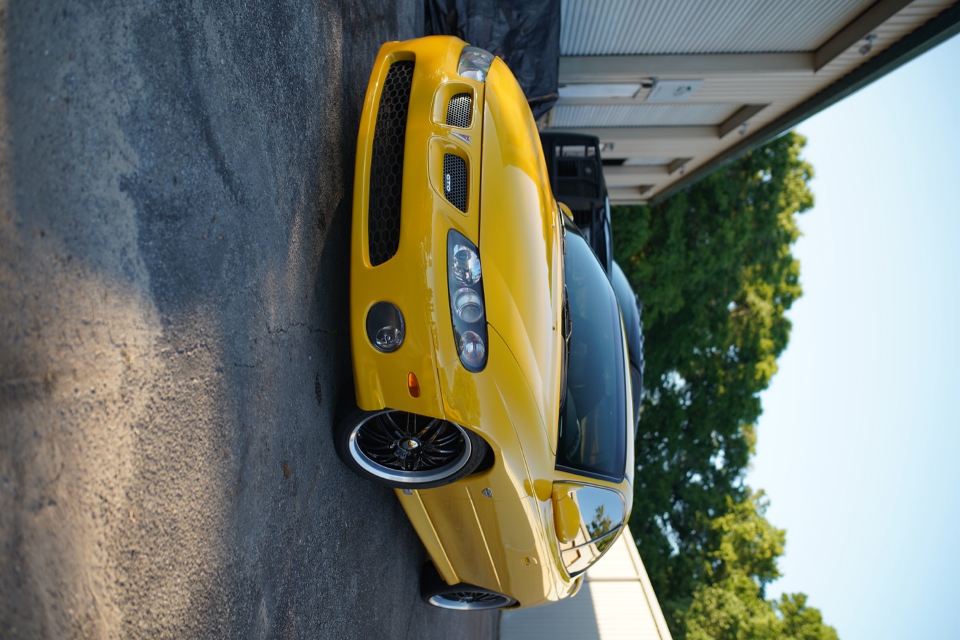 Yellow Pontiac GTO outside the shop